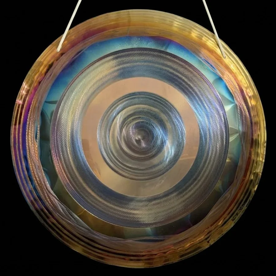 Handheld gong with a deep blue outer band and a pale silver spiral at the centre